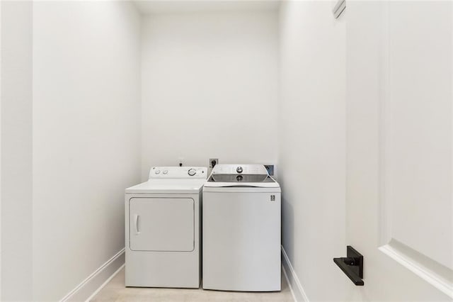 laundry area with laundry area, baseboards, and washing machine and clothes dryer