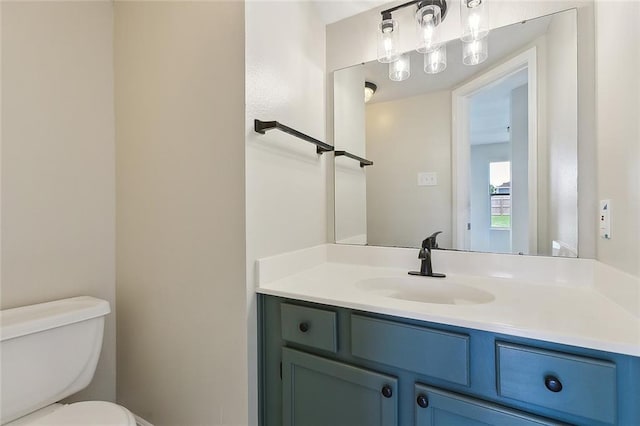 half bathroom featuring vanity and toilet