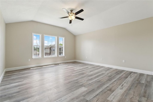 unfurnished room featuring baseboards, a ceiling fan, wood finished floors, and lofted ceiling