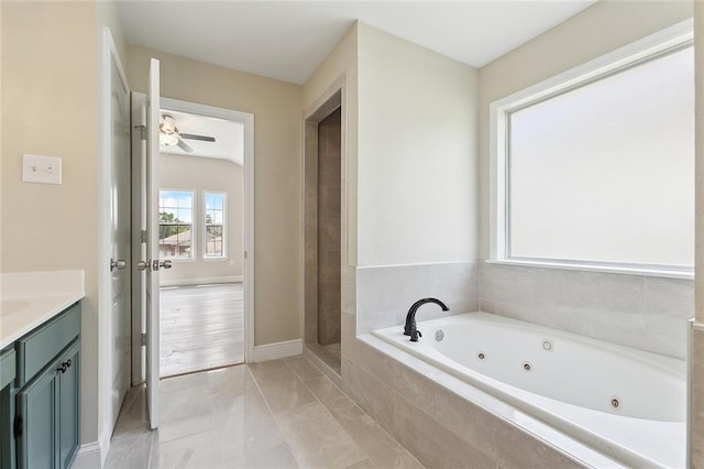 full bath featuring ceiling fan, vanity, marble finish floor, a whirlpool tub, and baseboards