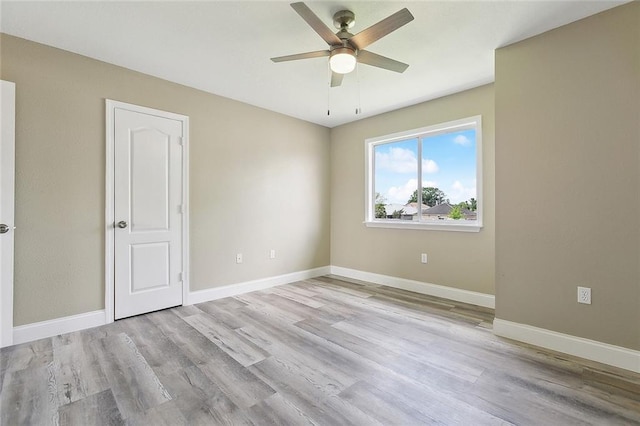 unfurnished room featuring baseboards, ceiling fan, and wood finished floors