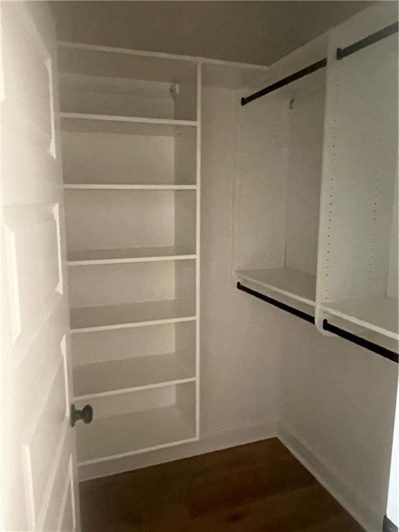 walk in closet with dark wood-type flooring
