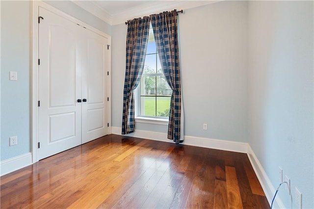 interior space with baseboards, ornamental molding, and hardwood / wood-style flooring