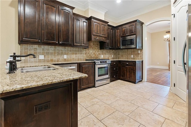 kitchen featuring backsplash, dark brown cabinets, a sink, light stone counters, and stainless steel appliances