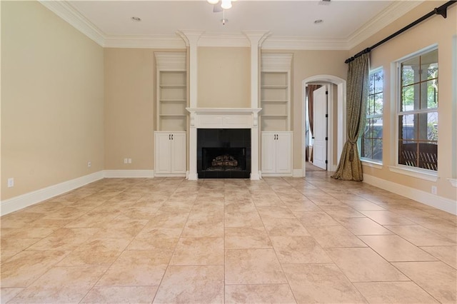 unfurnished living room featuring crown molding, arched walkways, baseboards, and a fireplace
