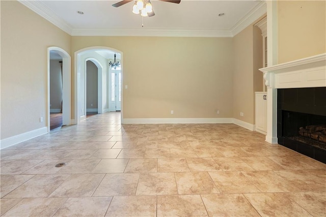 unfurnished living room featuring crown molding, arched walkways, a tiled fireplace, ceiling fan with notable chandelier, and baseboards