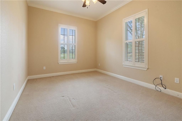 carpeted empty room with ceiling fan, ornamental molding, and baseboards
