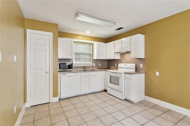 kitchen with visible vents, a sink, under cabinet range hood, white appliances, and white cabinetry