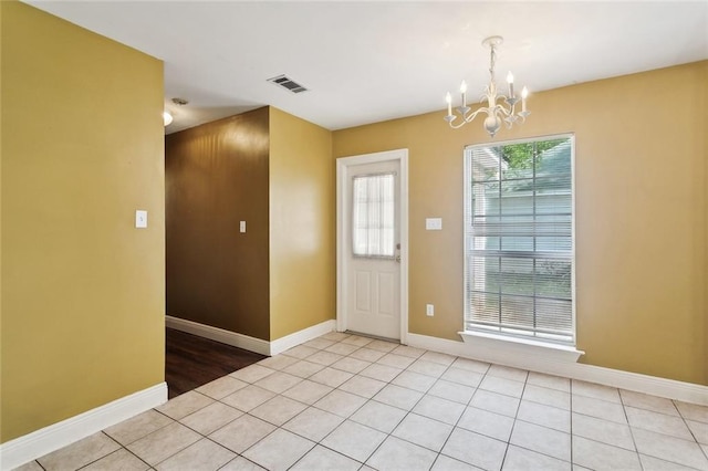 entryway featuring an inviting chandelier, baseboards, light tile patterned floors, and visible vents