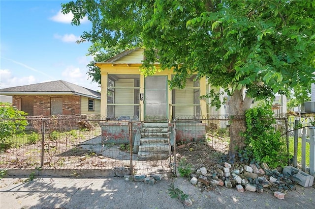 625 Forstall St, New Orleans, LA 70117 - view of front of home with brick siding, a fenced front yard, and a sunroom
