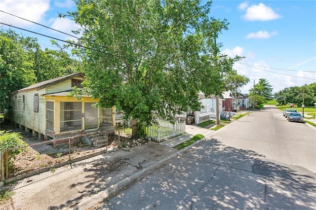 625 Forstall St, New Orleans, LA 70117 - view of property hidden behind natural elements with a sunroom, fence, and a residential view