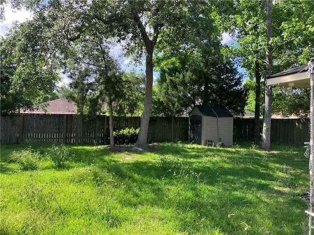 view of yard with an outdoor structure, a shed, and a fenced backyard