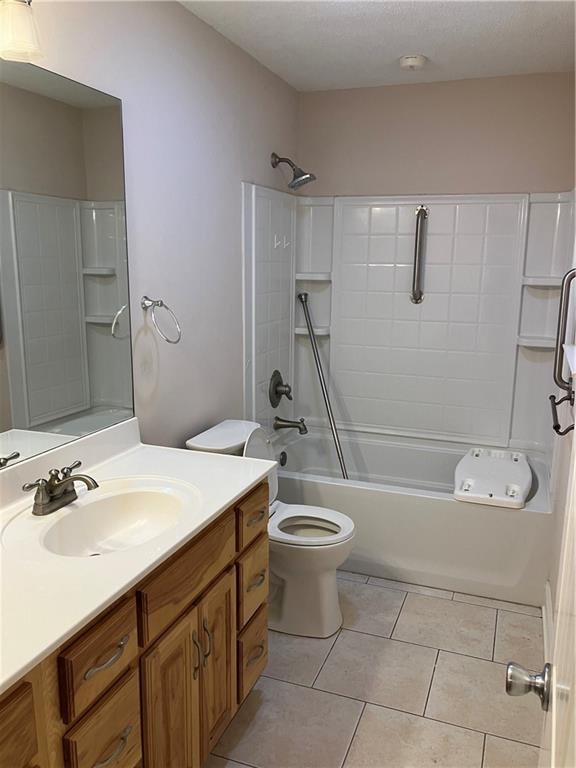 bathroom featuring vanity, tile patterned flooring, bathtub / shower combination, and toilet