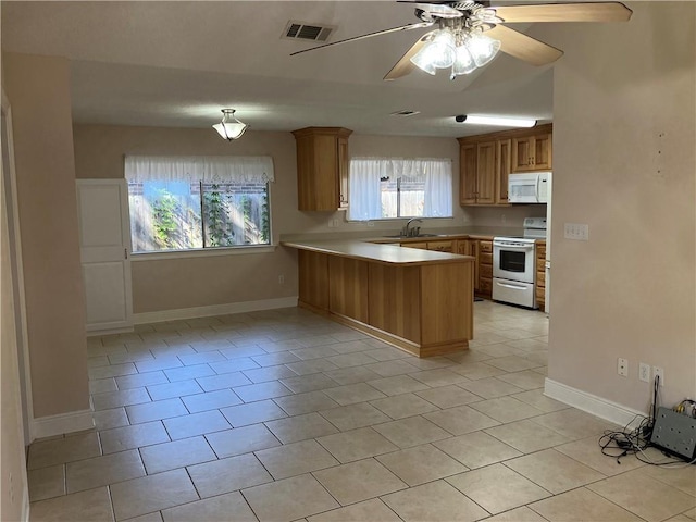 3837 Coventry St, Slidell, LA 70458 - kitchen featuring white appliances, a peninsula, light countertops, light tile patterned flooring, and ceiling fan
