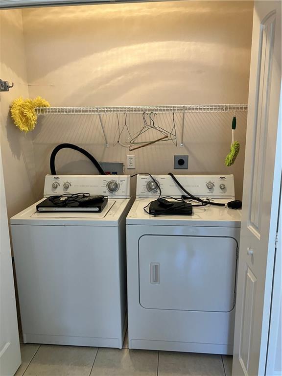 laundry area with light tile patterned floors, separate washer and dryer, and laundry area