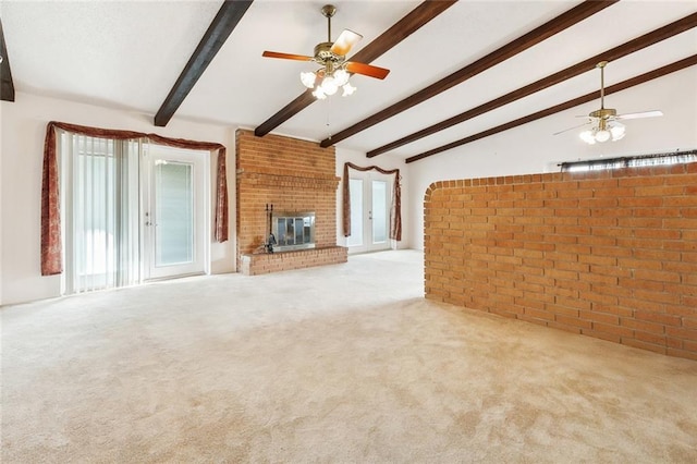 unfurnished living room with carpet floors, lofted ceiling with beams, ceiling fan, and a fireplace