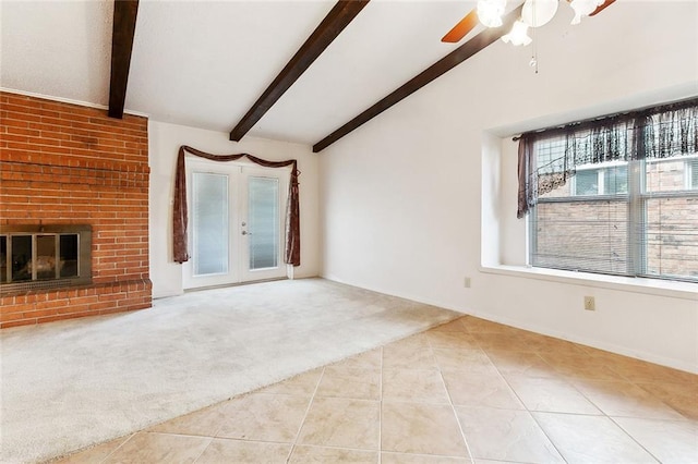 unfurnished living room featuring a ceiling fan, a fireplace, tile patterned floors, lofted ceiling with beams, and carpet