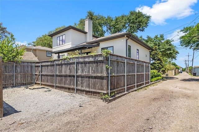 rear view of house with fence and a chimney