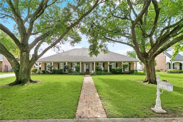 ranch-style house featuring brick siding, roof with shingles, and a front yard