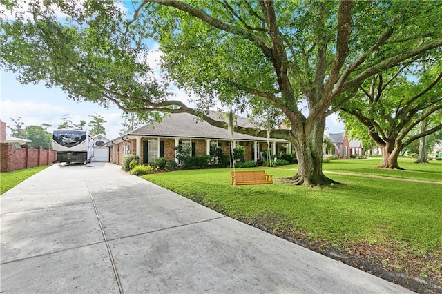ranch-style house with fence, driveway, brick siding, and a front yard