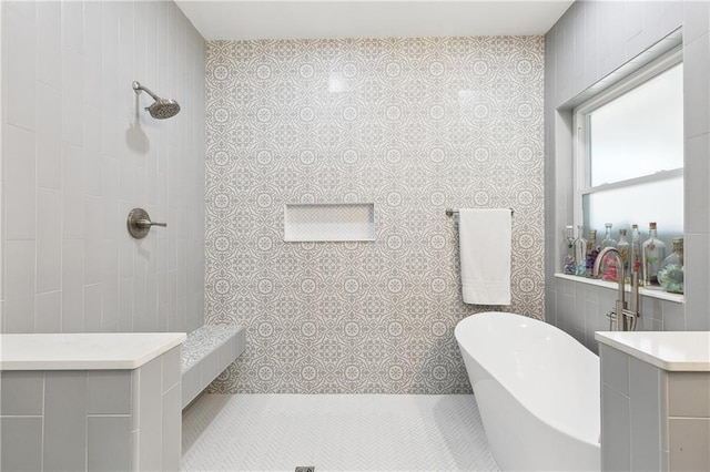 full bath with a freestanding tub, tile patterned floors, a tile shower, and tile walls