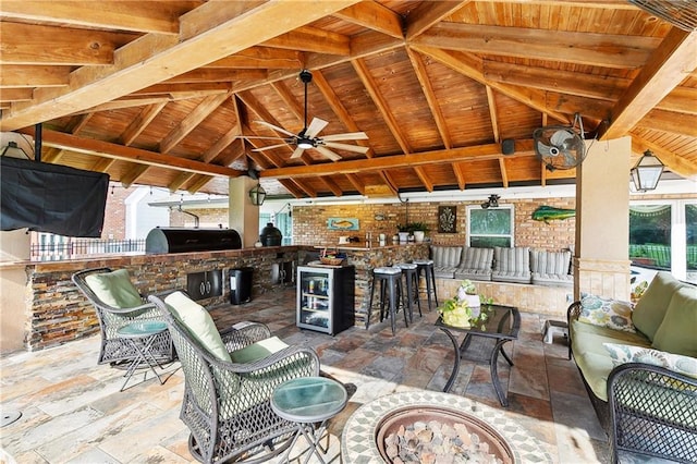 view of patio with outdoor wet bar, a gazebo, an outdoor kitchen, beverage cooler, and a ceiling fan
