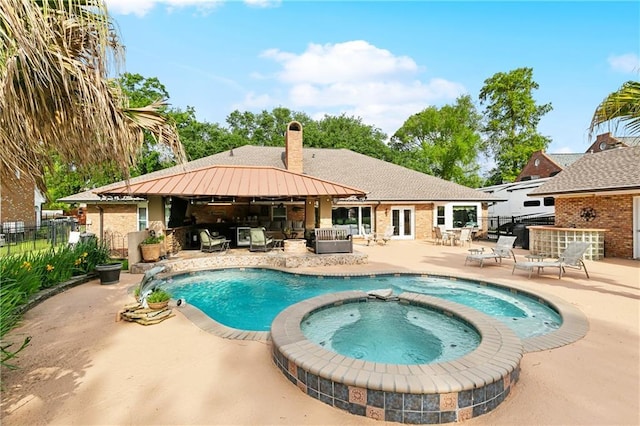 view of swimming pool with fence, a pool with connected hot tub, an outdoor hangout area, a patio area, and french doors