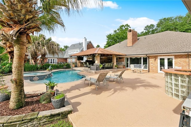 view of swimming pool with a patio, a pool with connected hot tub, fence, and a gazebo