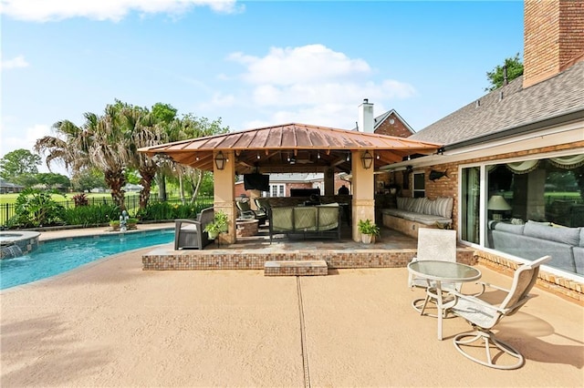 view of patio featuring fence, a gazebo, and a pool with connected hot tub