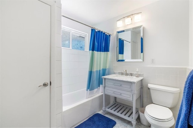 20 Thrasher St, New Orleans, LA 70124 - bathroom featuring vanity, toilet, shower / bathtub combination with curtain, a wainscoted wall, and tile walls
