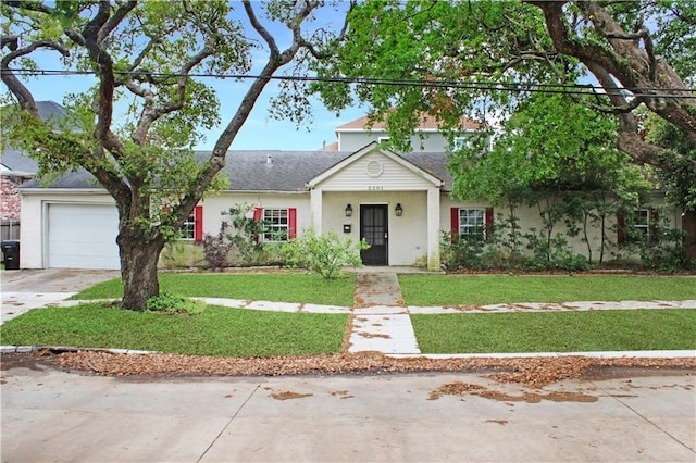 view of front of house with concrete driveway, roof with shingles, an attached garage, and a front yard