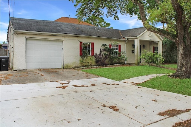 ranch-style house featuring an attached garage, a front yard, brick siding, and concrete driveway