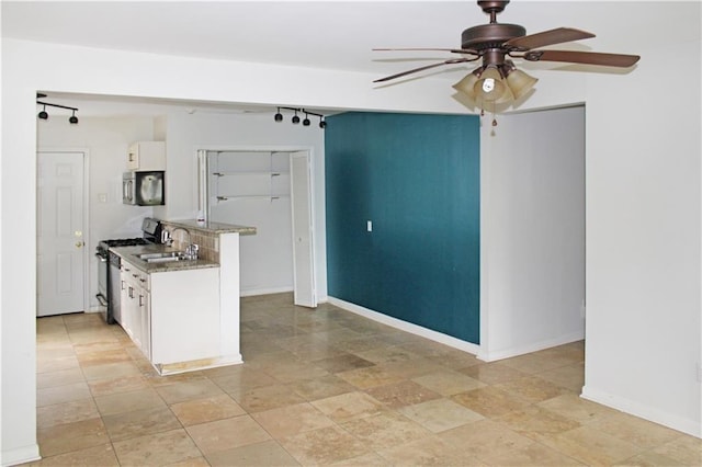 kitchen with ceiling fan, appliances with stainless steel finishes, a sink, rail lighting, and white cabinetry
