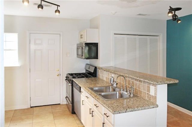 kitchen featuring a sink, a peninsula, white cabinets, and stainless steel appliances