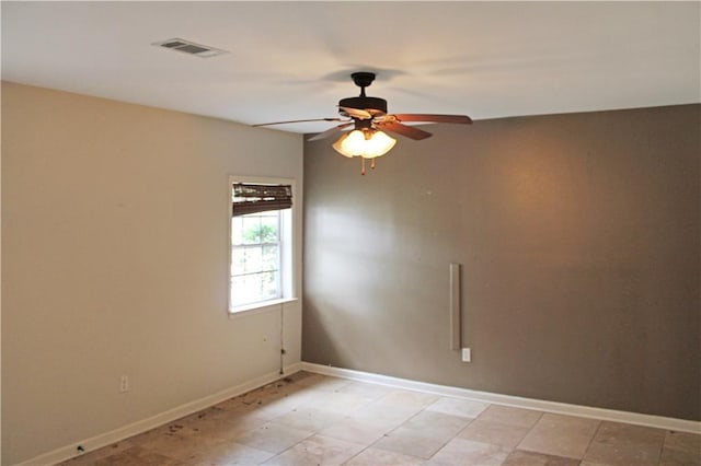 spare room with visible vents, a ceiling fan, and baseboards