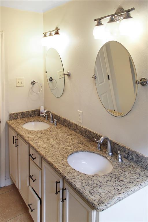 bathroom featuring double vanity, a sink, and tile patterned flooring