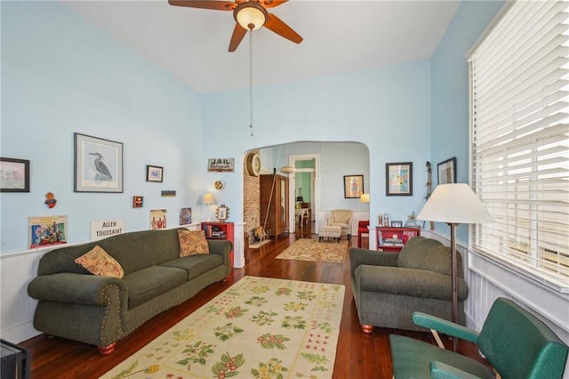 living room featuring a high ceiling, ceiling fan, and wood finished floors