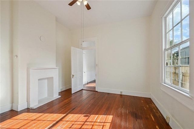 unfurnished living room with baseboards, a ceiling fan, and hardwood / wood-style flooring