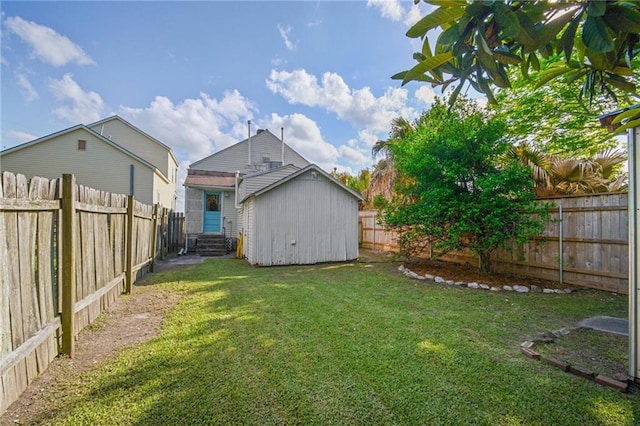 view of yard with a fenced backyard, an outdoor structure, and entry steps