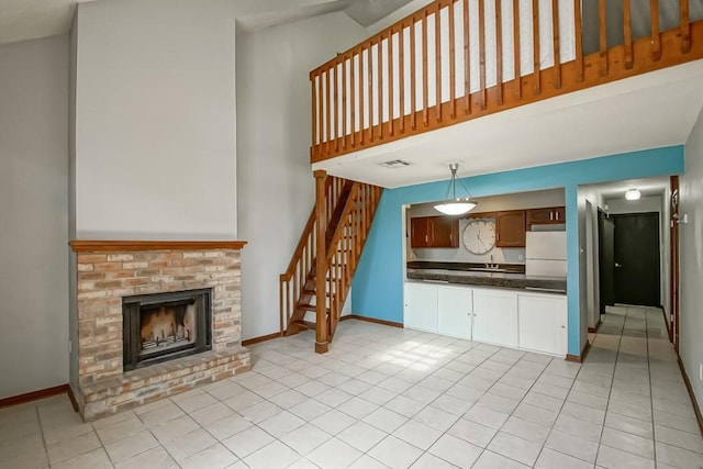2441 Chartres St, New Orleans, LA 70117 - interior space with a towering ceiling, a fireplace, baseboards, stairway, and light tile patterned floors