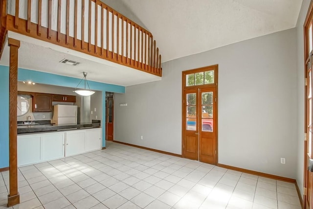 2441 Chartres St, New Orleans, LA 70117 - unfurnished living room featuring a sink, baseboards, high vaulted ceiling, and visible vents