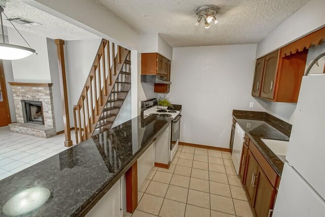 2441 Chartres St, New Orleans, LA 70117 - kitchen featuring light tile patterned flooring, white appliances, a textured ceiling, and visible vents