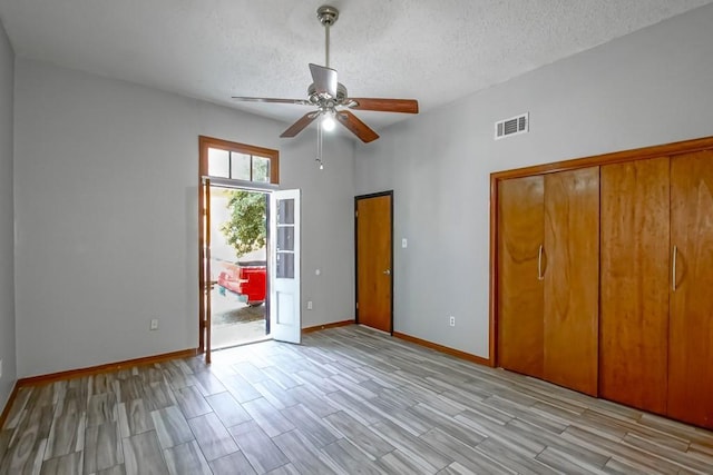 2441 Chartres St, New Orleans, LA 70117 - unfurnished bedroom featuring visible vents, access to exterior, baseboards, wood tiled floor, and a textured ceiling