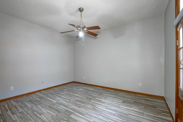 2441 Chartres St, New Orleans, LA 70117 - empty room featuring light wood-style floors, a textured ceiling, baseboards, and ceiling fan