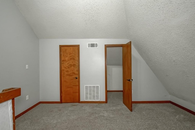 2441 Chartres St, New Orleans, LA 70117 - bonus room with a textured ceiling, vaulted ceiling, baseboards, and visible vents