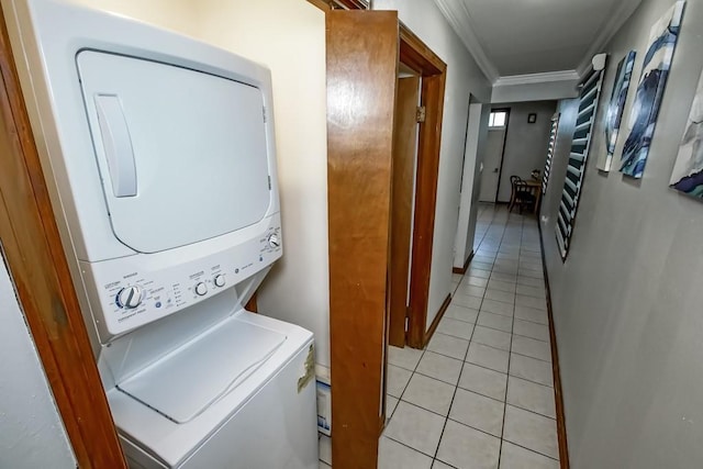 2441 Chartres St, New Orleans, LA 70117 - laundry room featuring laundry area, ornamental molding, light tile patterned flooring, and stacked washer / dryer