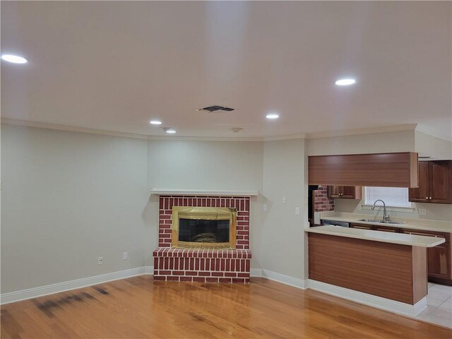 3513 Lemon St, Metairie, LA 70006 - kitchen with freestanding refrigerator, black electric stovetop, under cabinet range hood, brown cabinets, and light countertops