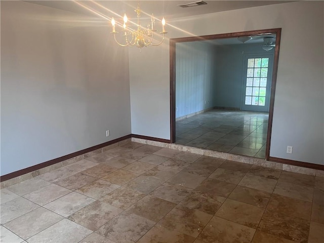 empty room with a chandelier and baseboards