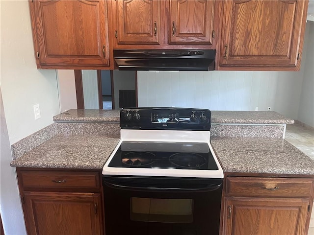 kitchen featuring black / electric stove, under cabinet range hood, and brown cabinets