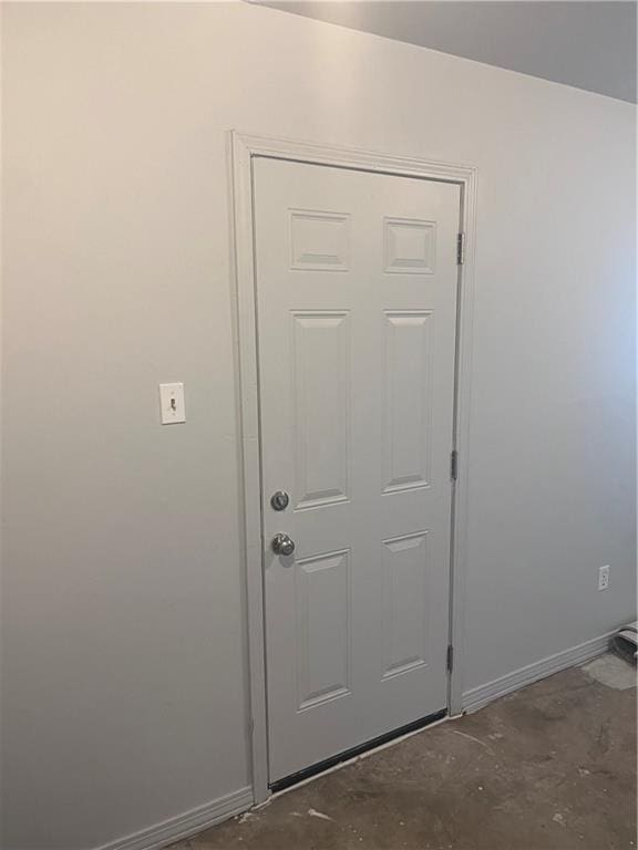 entryway featuring concrete floors and baseboards